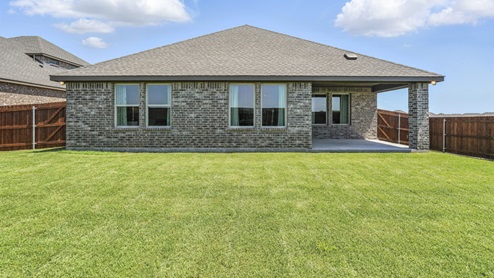 rear exterior of home featuring a spacious backyard