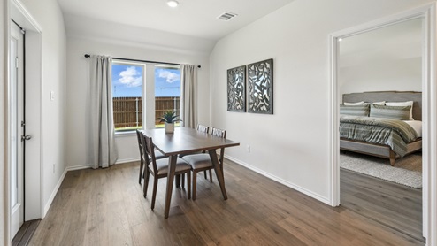 dining room next to the kitchen featuring a brown rectangular table and chairs