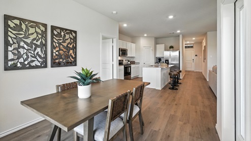 dining room next to the kitchen featuring a brown rectangular table and chairs