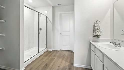 bathroom with dual vanity sinks, toilet, bath tub and a walk in shower