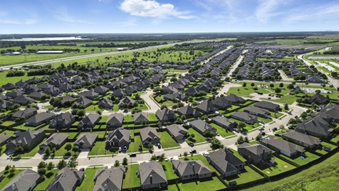 Ariel view of the Saddlebrook community featuring a pond and street views of the homes