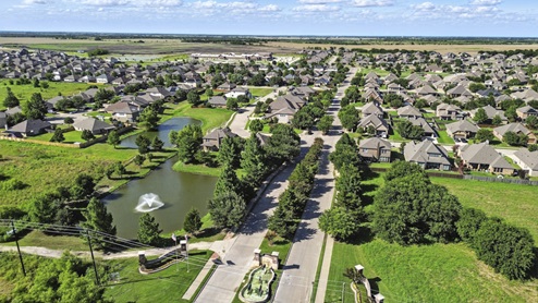 Ariel view of the Saddlebrook community featuring a pond and street views of the homes