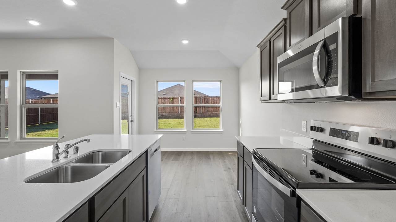 kitchen with sink and stainless steel appliances overlooking breakfast nook