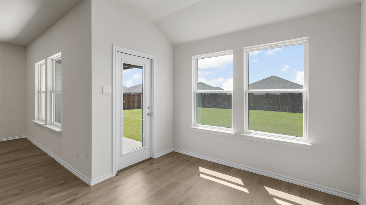 breakfast nook area with back door and large double windows