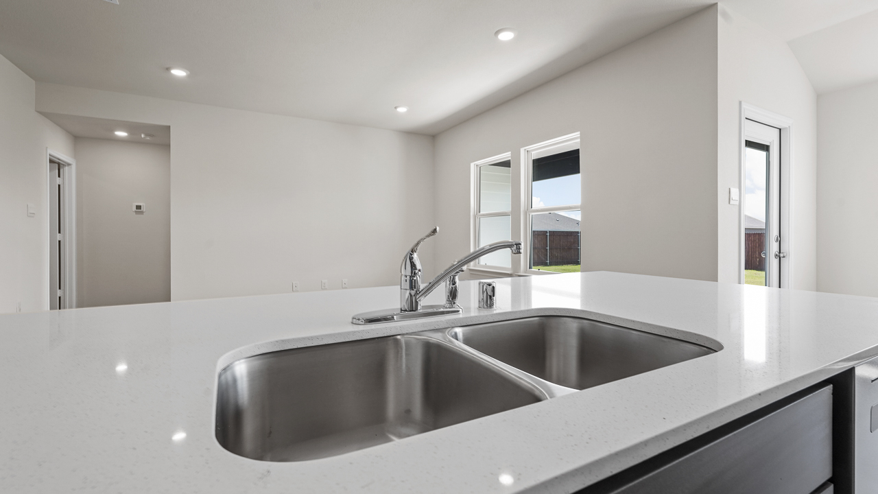 close up of white countertop island and double sink