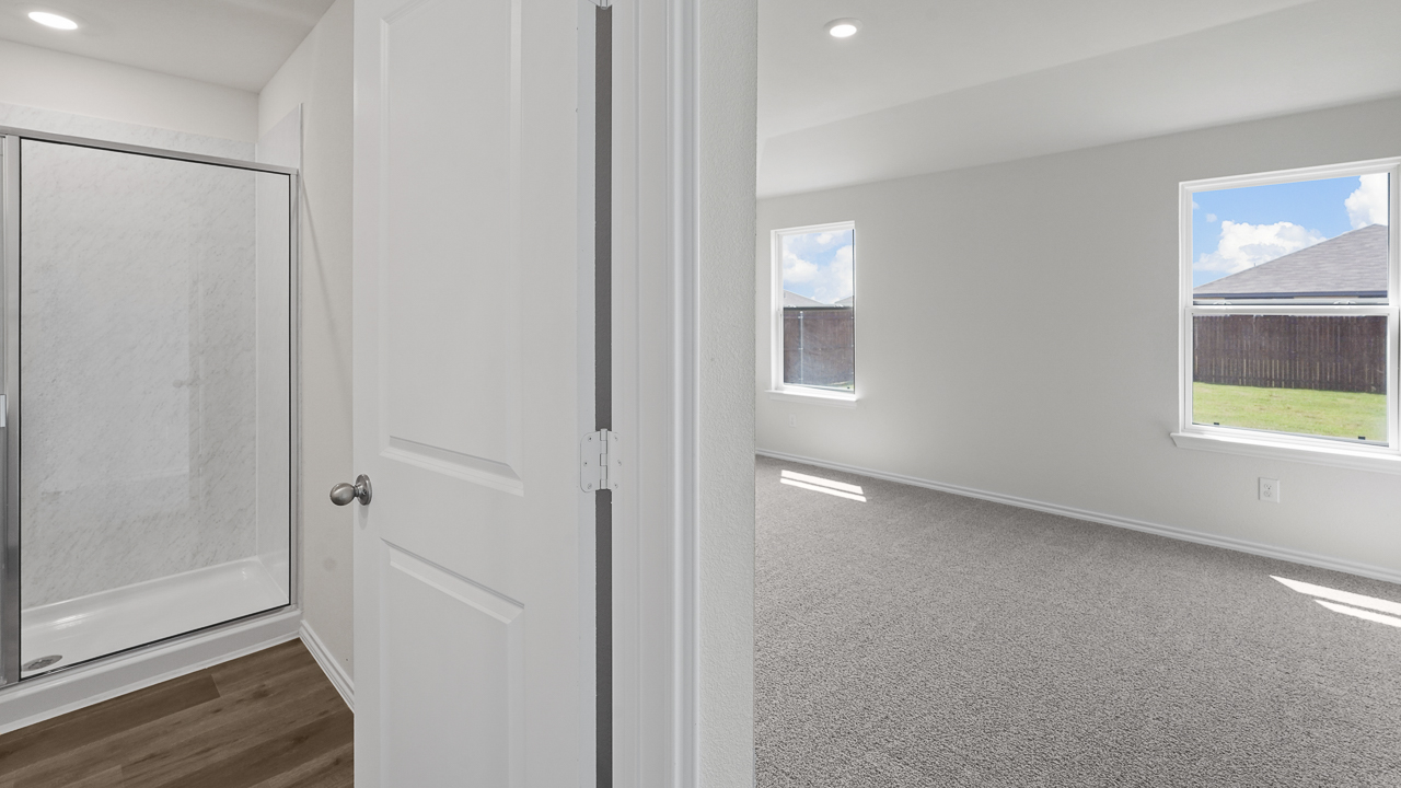 view of large primary bedroom and primary bathroom with shower