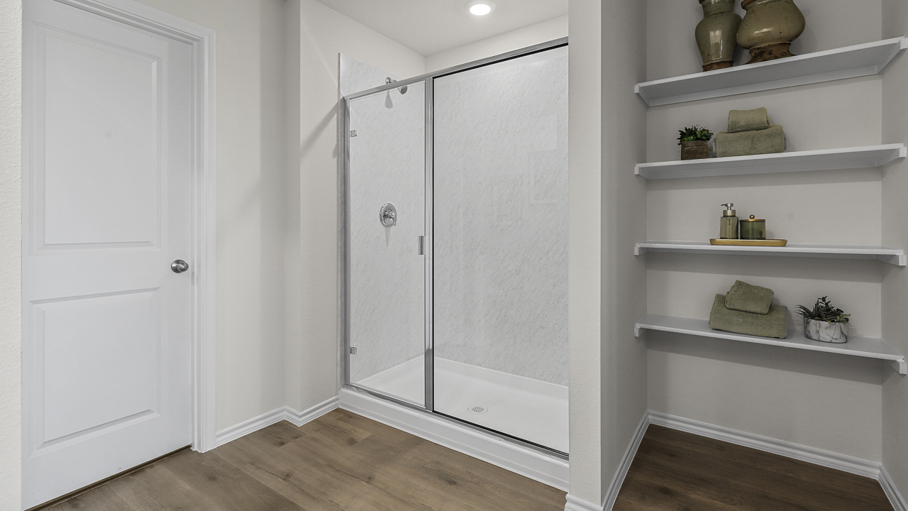 primary bathroom with walkin shower and storage shelves