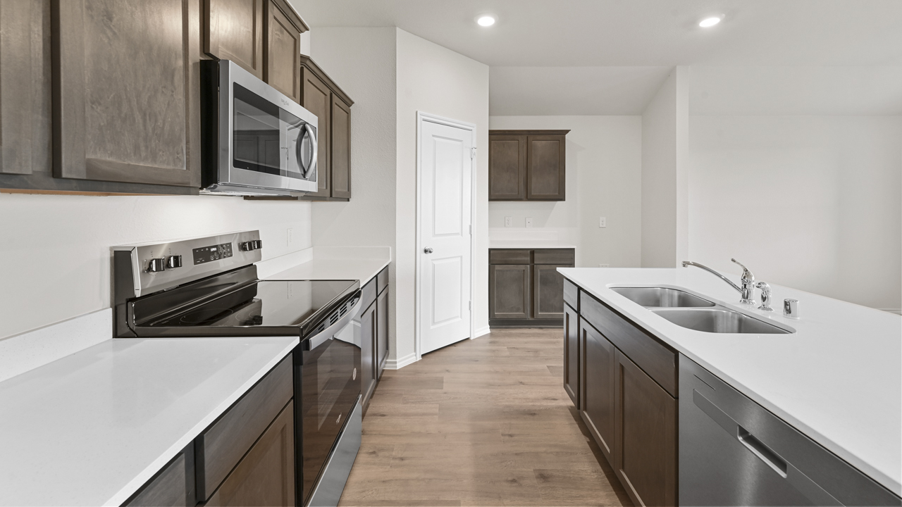 kitchen with elongated countertops and white counters with brown cabinets
