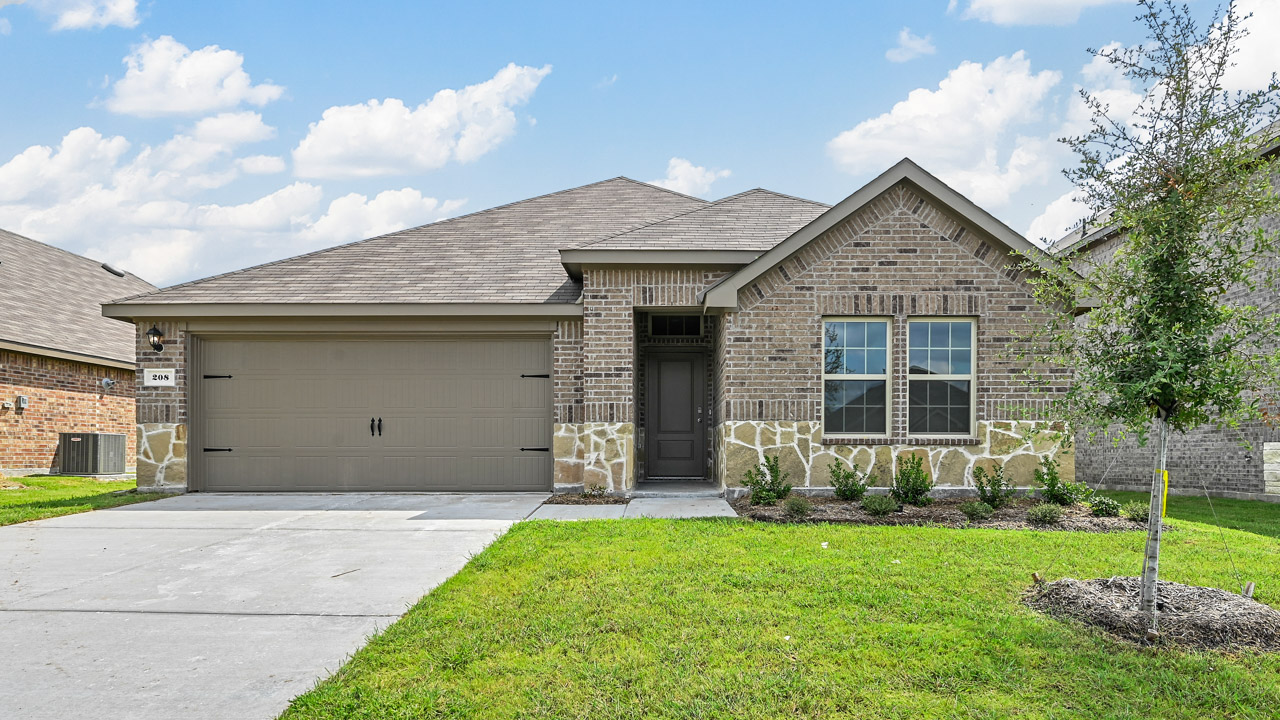single story home with brick and stone and green grass with tree