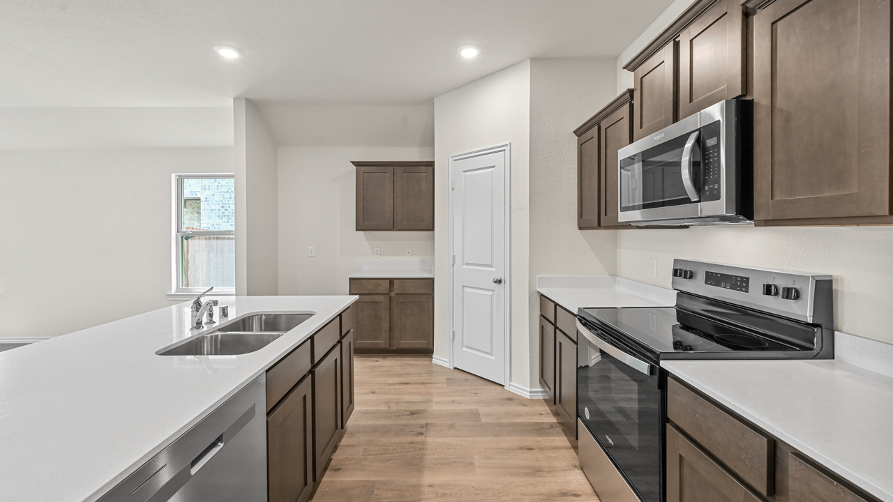kitchen with elongated white counters and brown cabinets