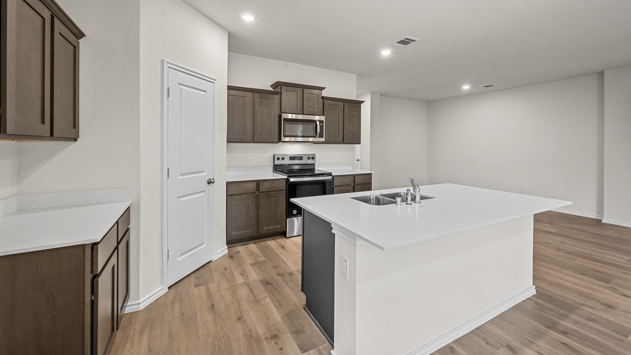 full view of kitchen with brown cabinets and walk in pantry