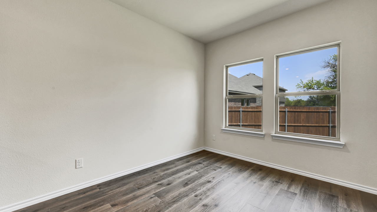 bedroom with wood plank vinyl floors and two large windows