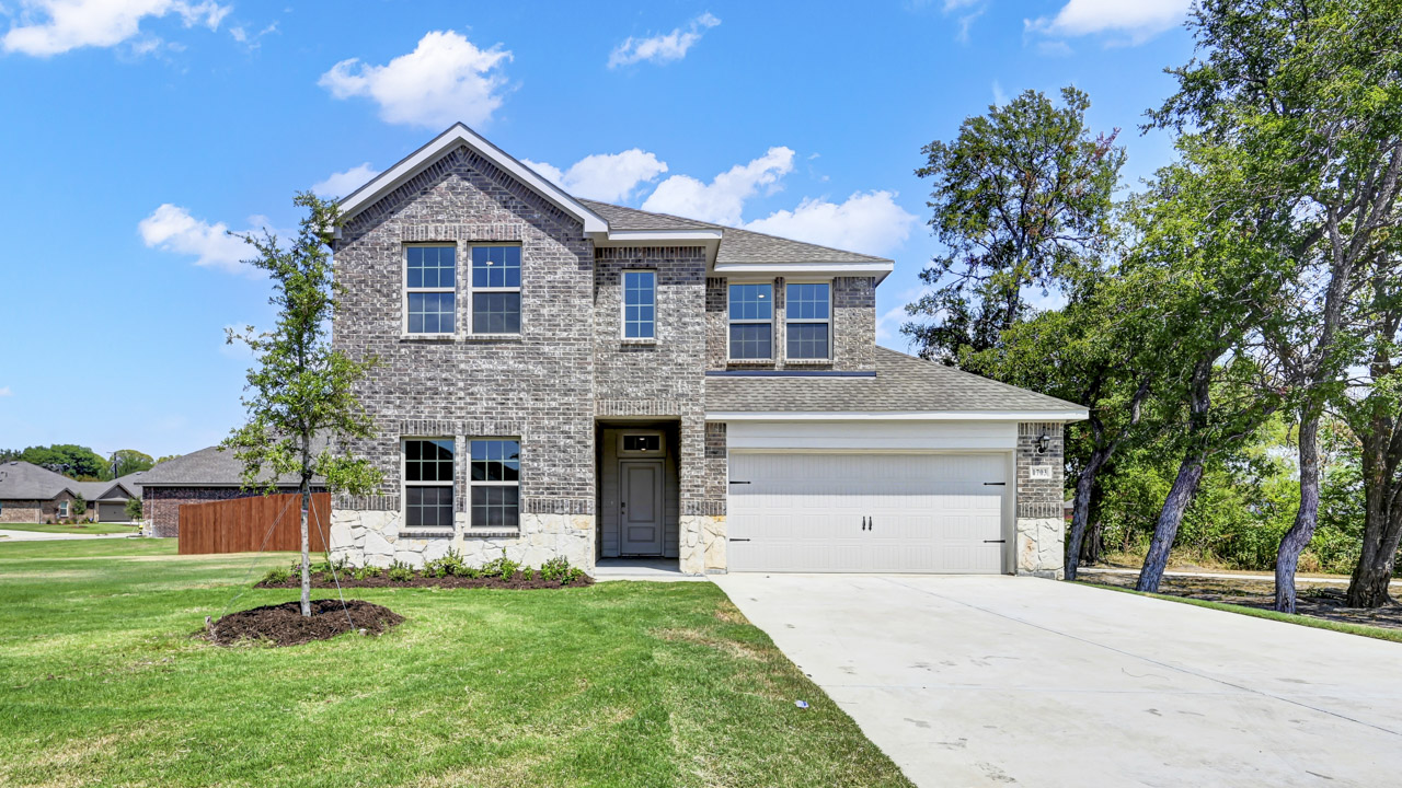 large two story home with gray brick and white stone