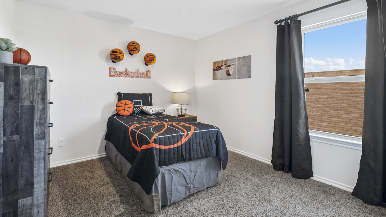 secondary bedroom with window and basketball themed decor