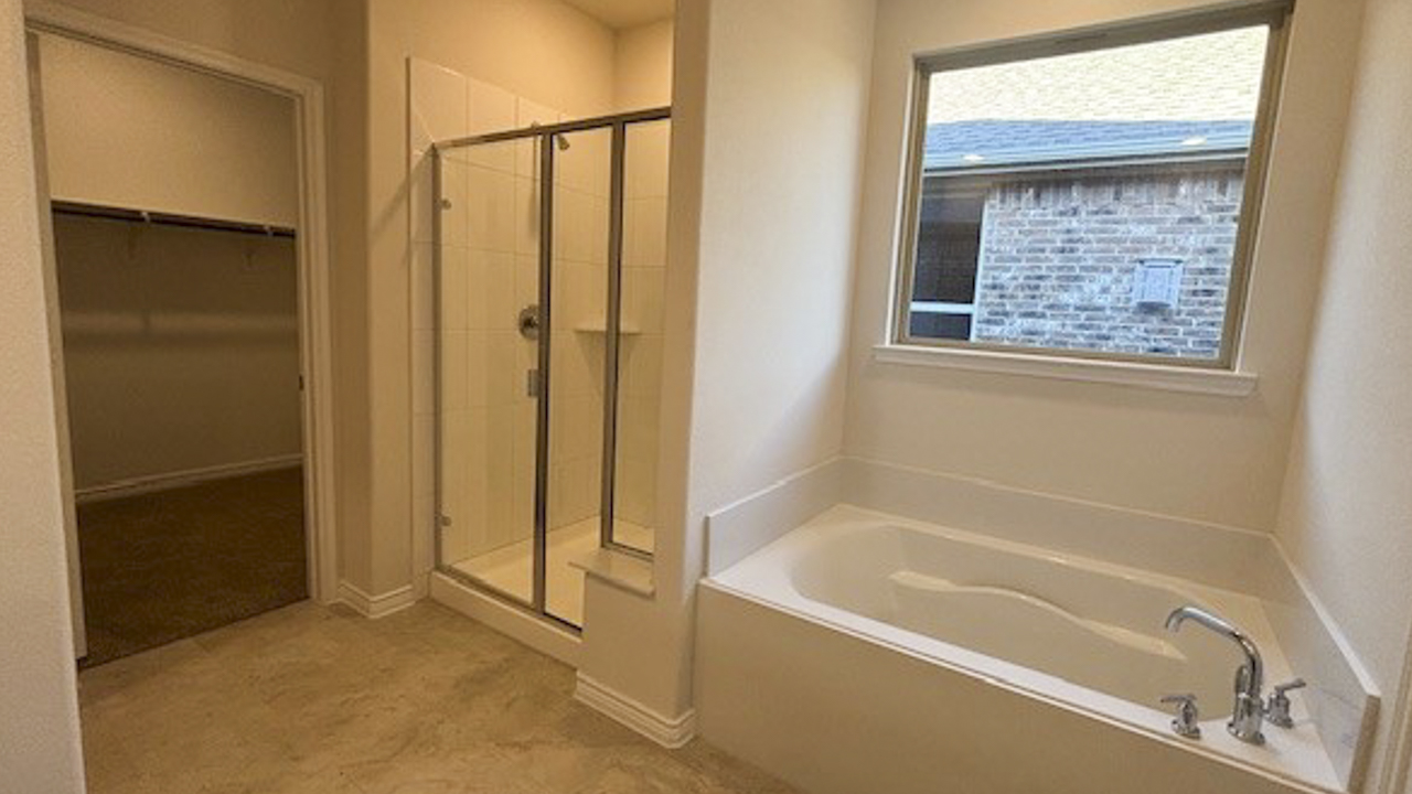 primary bathroom with tile stand up shower and tub