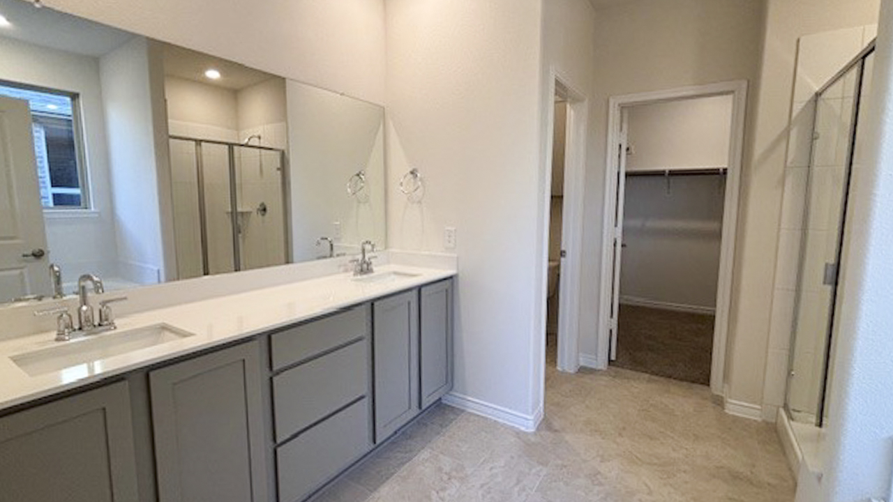 primary bathroom with tile white counters and grey cabinets