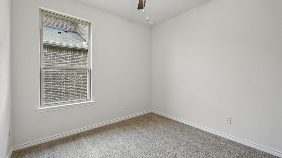 secondary bedroom with carpet and large window