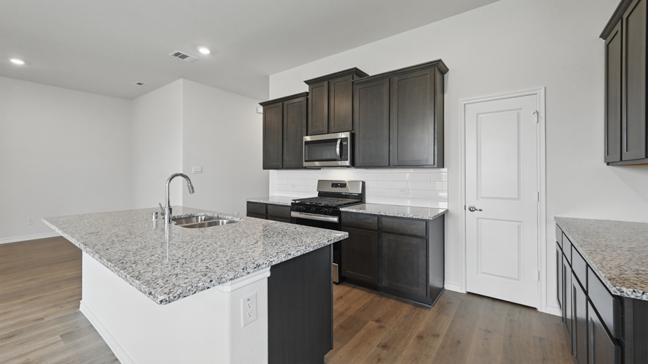 kitchen area with hardwood floors white counters and dark cabinets