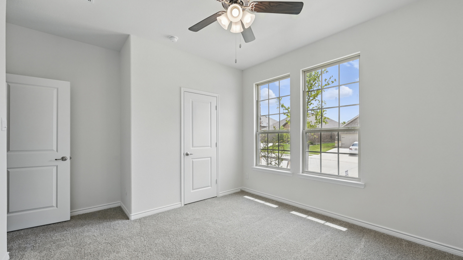 secondary bedroom with carpet and large window providing natural light with white walls