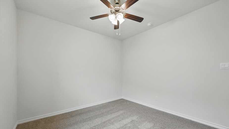 secondary bedroom with carpet and large window providing natural light with white walls