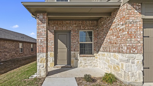 Two story home with brick stone and siding and covered front porch