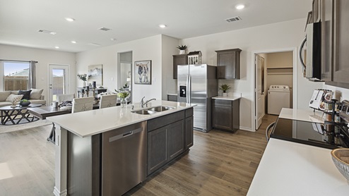 2015 Wildcat Trail model home at Wildcat Ranch in Crandall, TX kitchen area with view of open concept living area