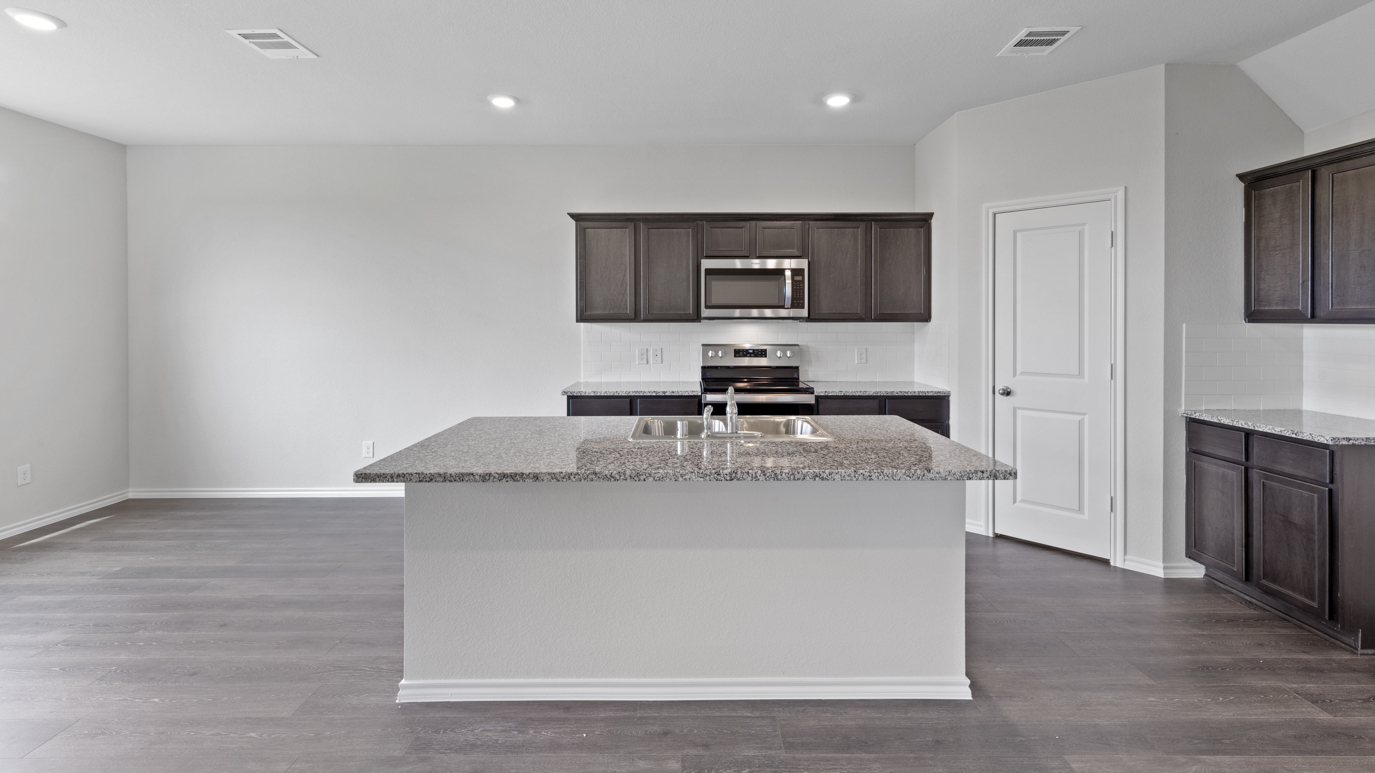 X30G kitchen area with granite countertops and dark cabinets