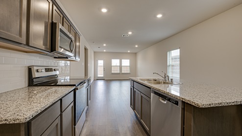 X30J kitchen area with granite countertops and dark cabinets