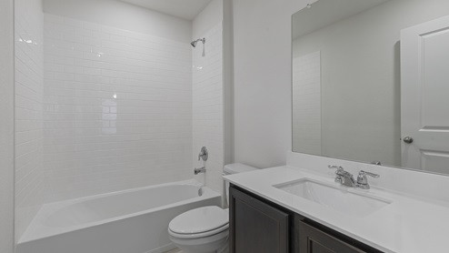 X30E secondary bathroom with white countertops and dark cabinets
