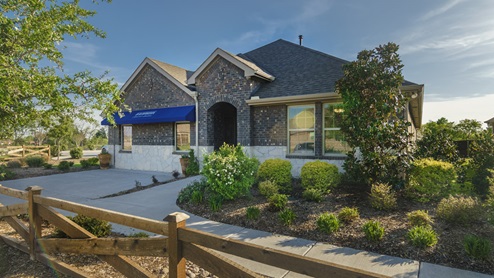 One story Trailstone model home with blue D.R. Horton awning and beautiful landscaping