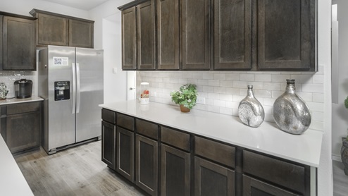 Large kitchen with elongated hard surface countertop and stainless steel appliances