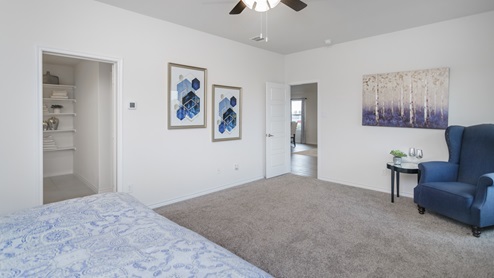 Large primary bedroom with two windows and furnishings