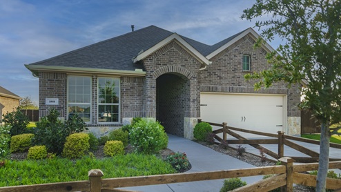 One story model home with beautiful landscaping and a tree