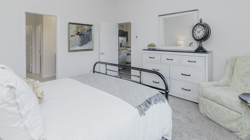 Large primary bedroom with large window and bedroom furniture