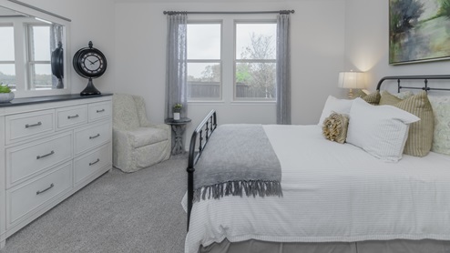 Large primary bedroom with large window and bedroom furniture