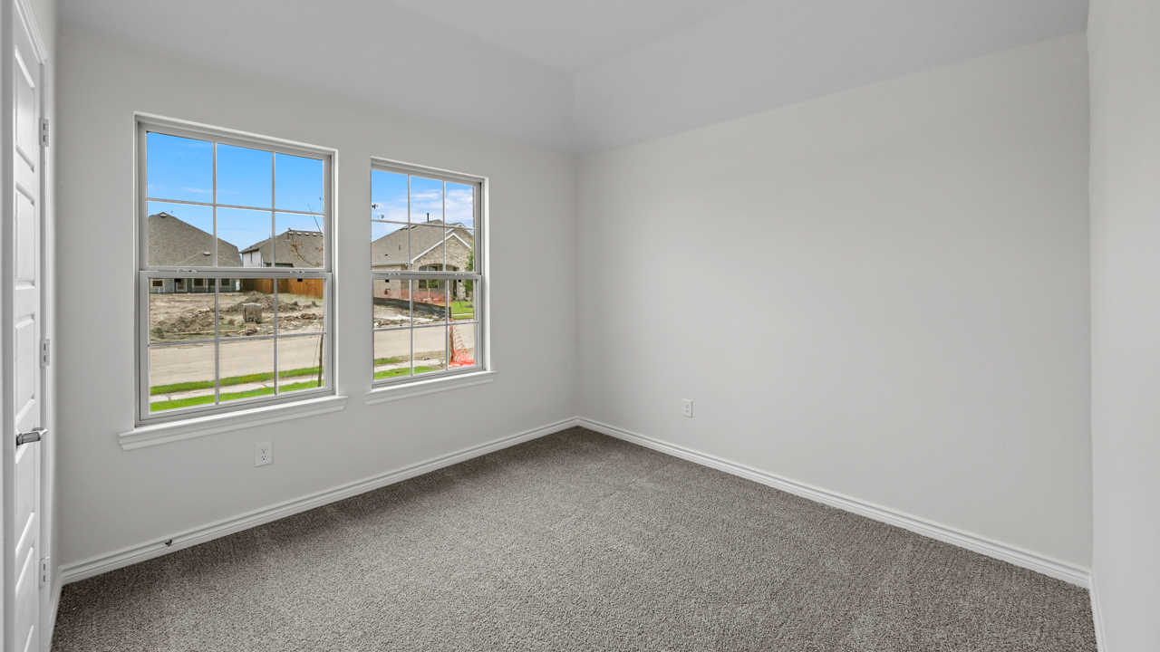 open bedroom with gray carpet and windows