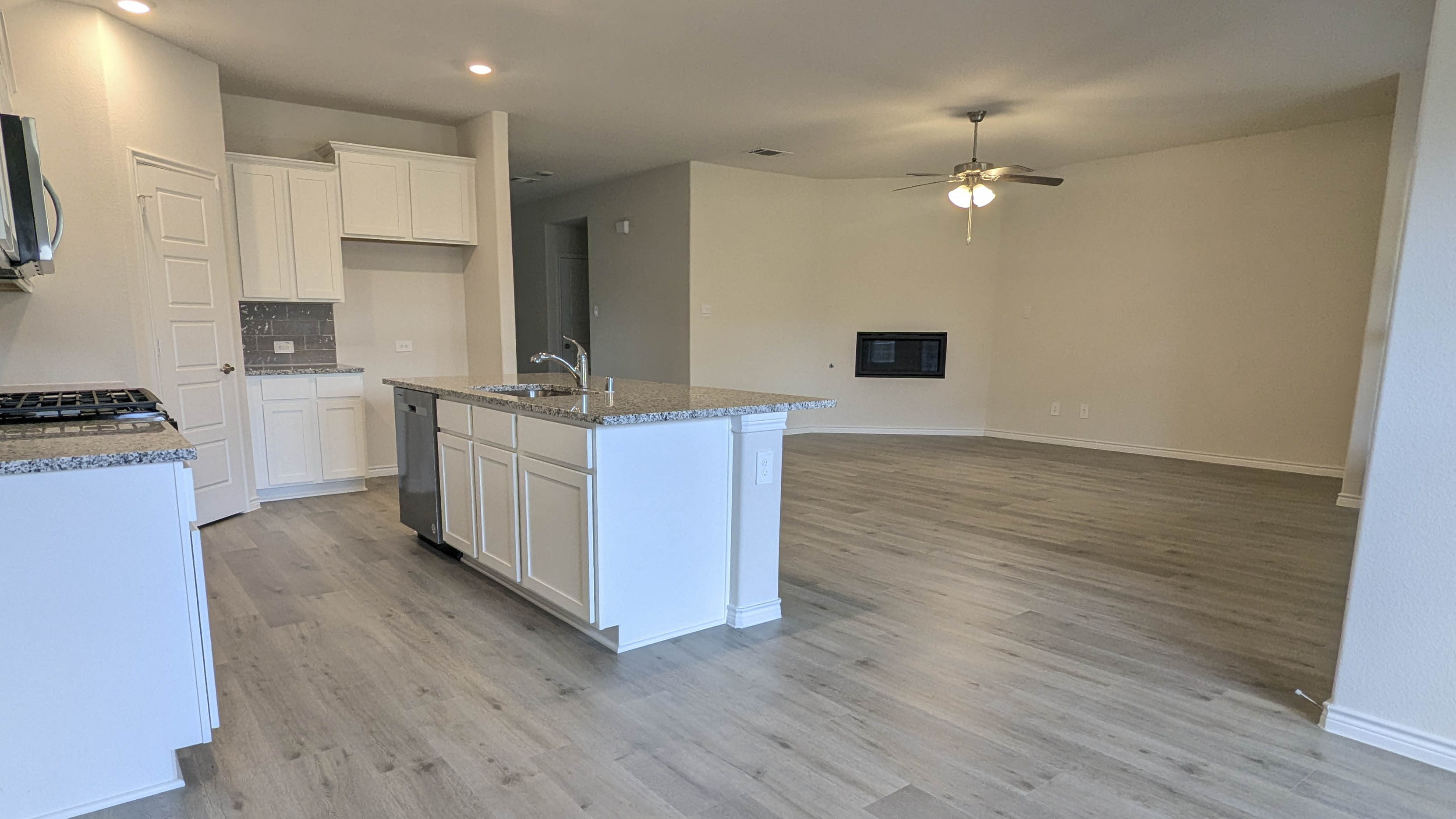 dining and living area with hardwood floors white cabinets and granite counters