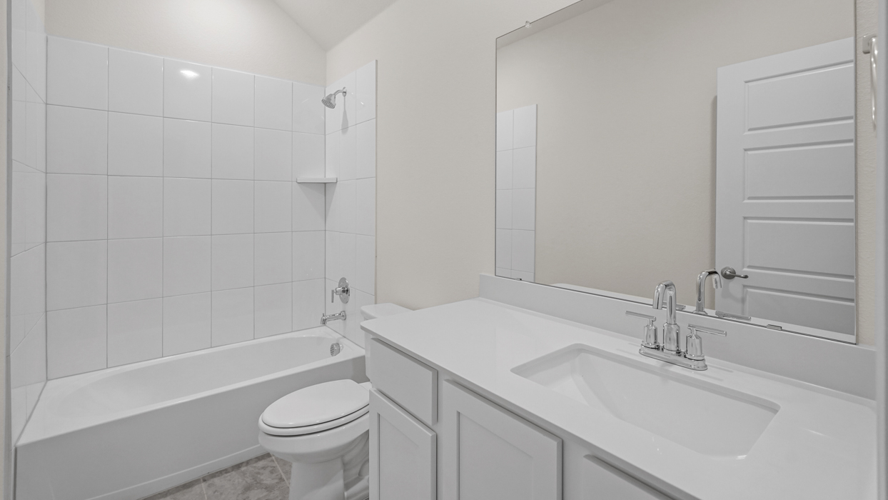 secondary bathroom with elongated vanity with white countertops and cabinets