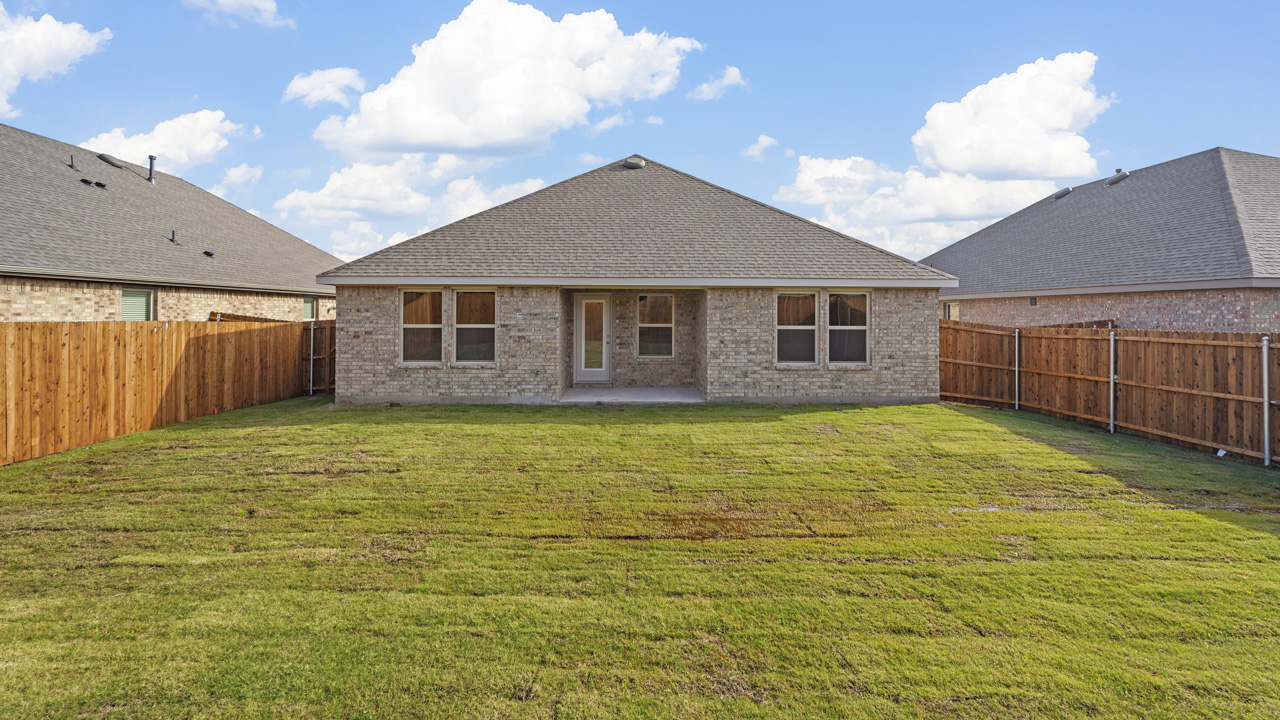 exterior of back side of home with windows and covered patio