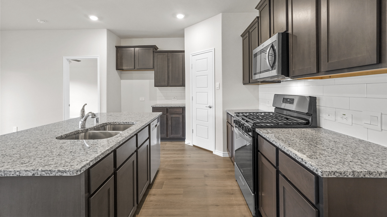 large kitchen with elongated granite countertops and brown cabinets