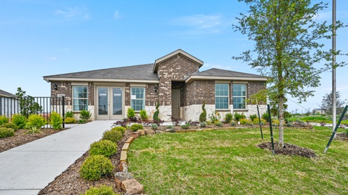 A one-story model home with stone at the bottom of the elevation and brown brick