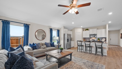 A large open living room where you can also see the kitchen