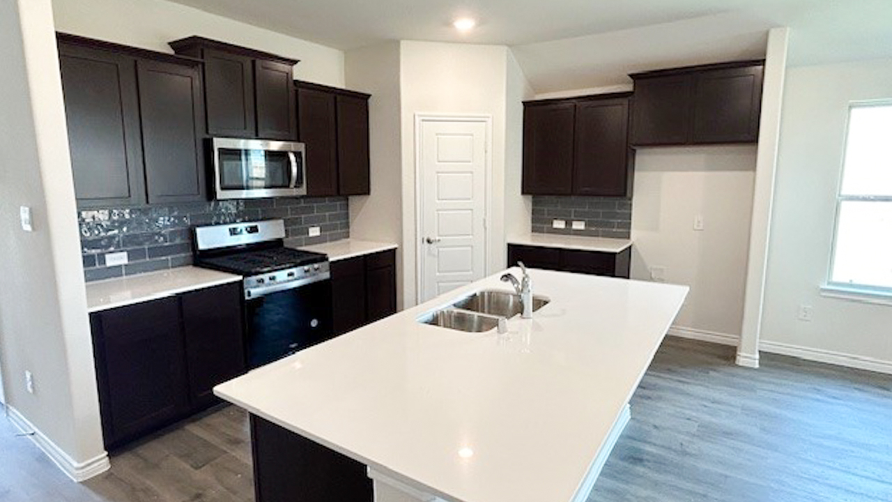kitchen area with dark cabinets and white counters