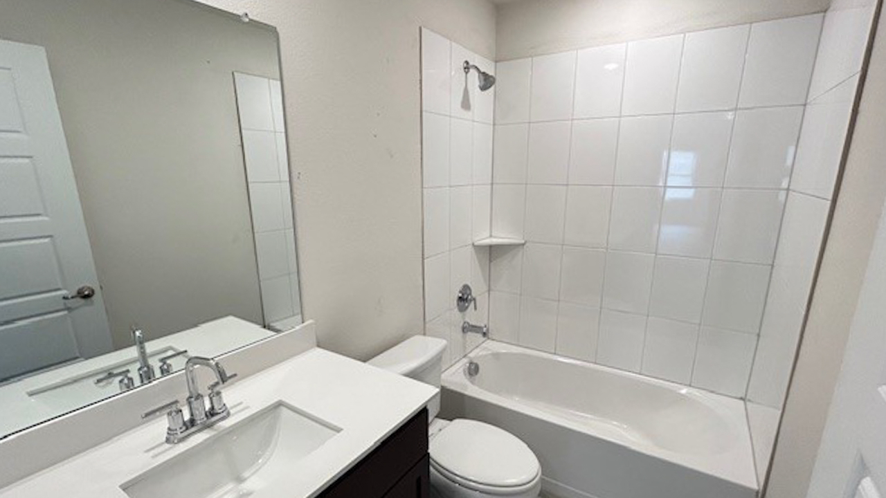 secondary bathroom white counters and dark cabinets