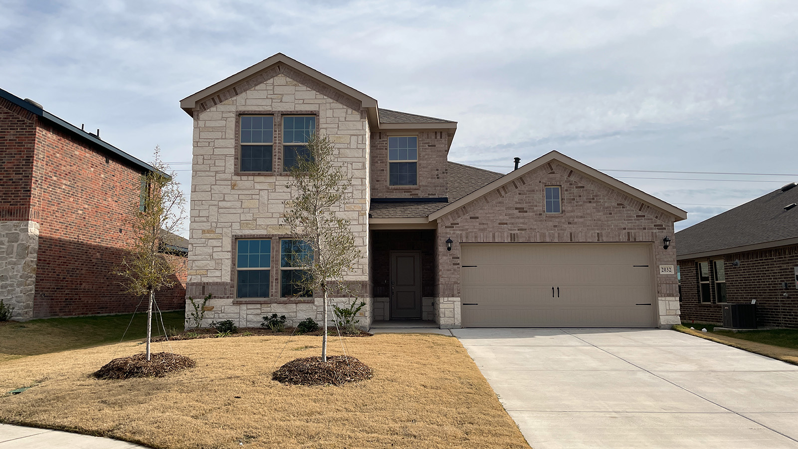 Two story home with brick and stone and two car garage