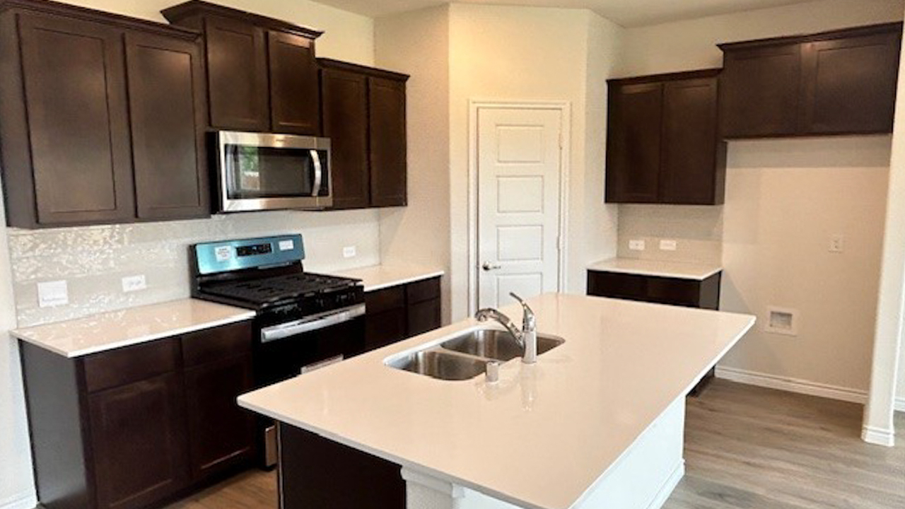 kitchen area with dark cabinets and light colored counters