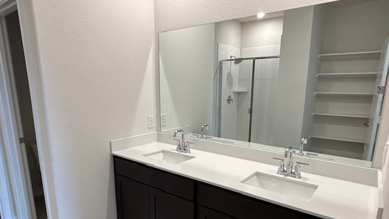 primary bathroom with white counters and dark cabinets