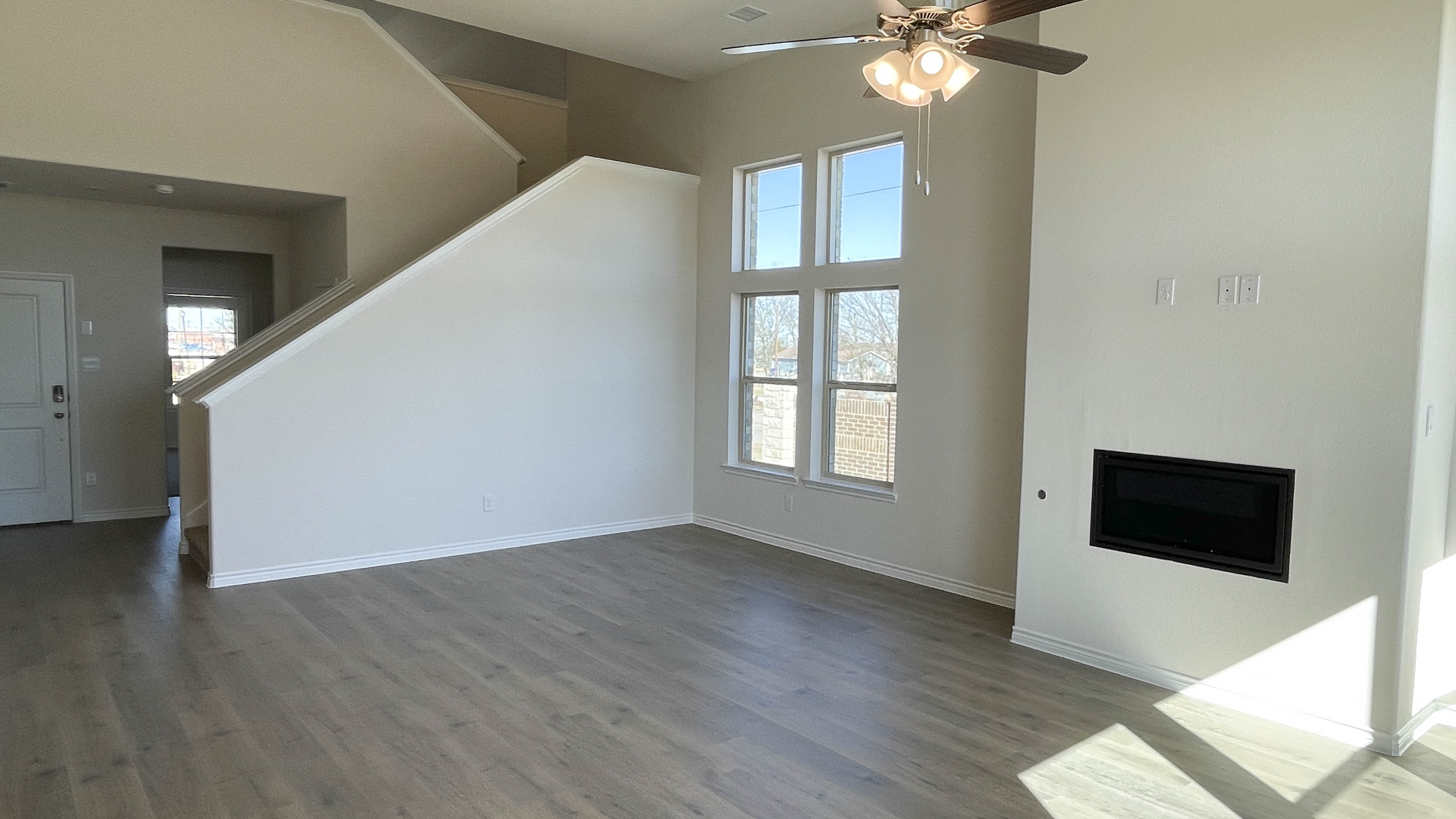 open concept living area with hardwood floors and large windows providing natural light
