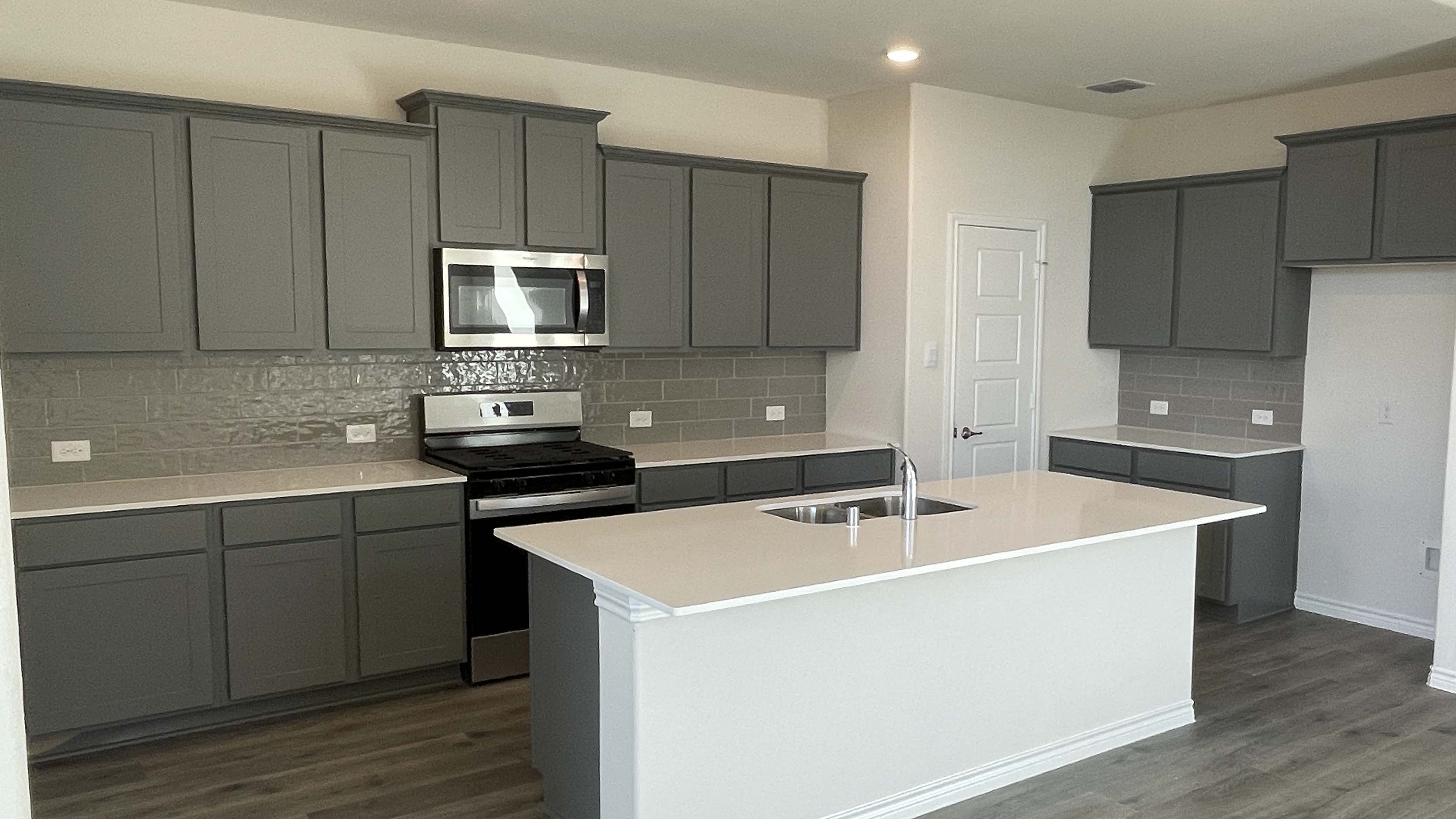 kitchen area with dark cabinets and light colored counters
