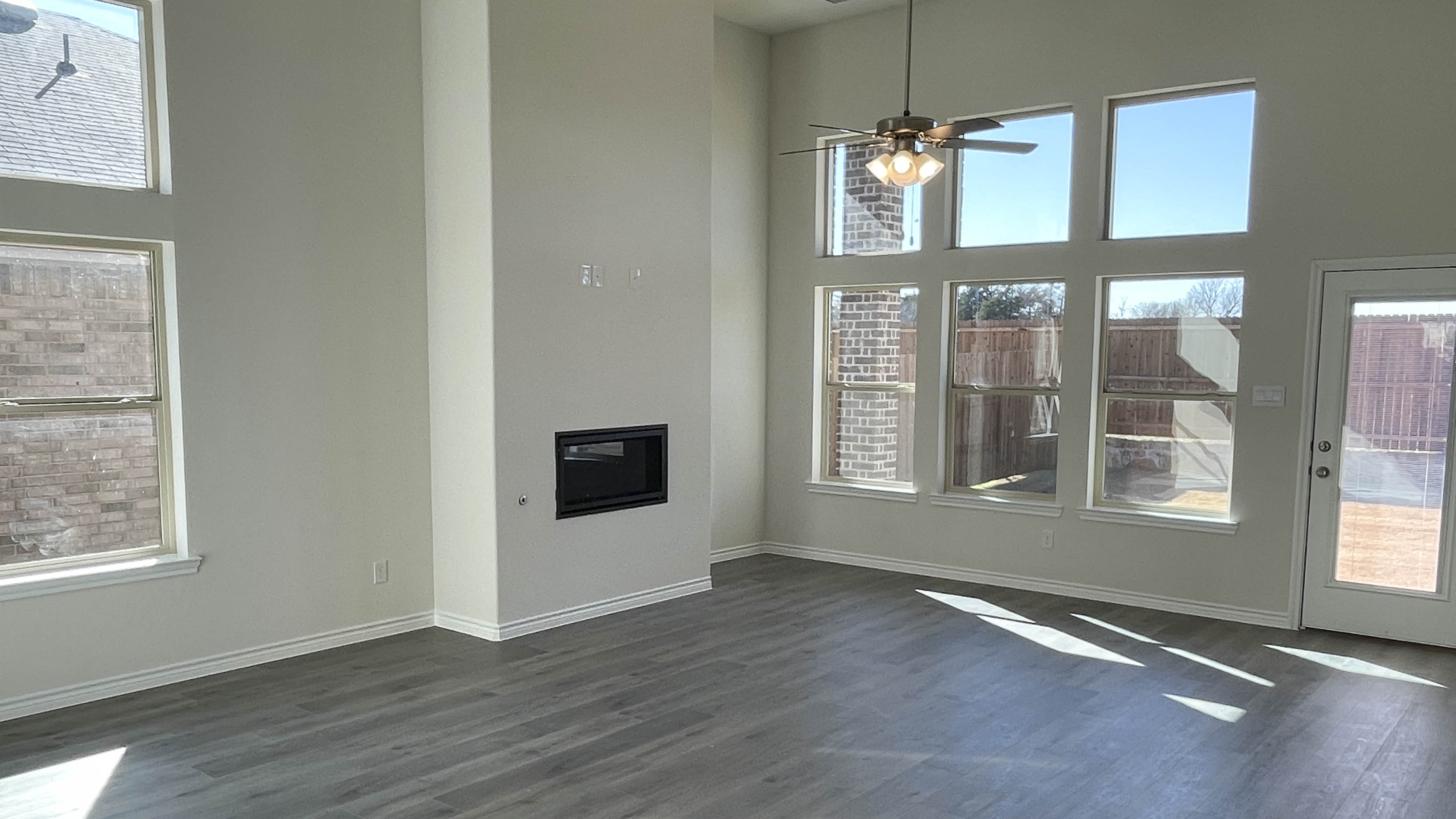 open concept living area with hardwood floors and large windows providing natural light
